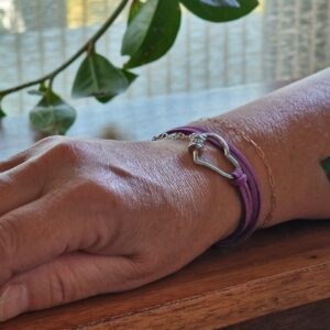 Bracelet double tour en faux daim mauve, orné d’une boucle argentée en forme de cœur et d’un fermoir avec zircon CZ. Composé d’acier inoxydable 304 avec une rallonge décorative en forme de cœurs.