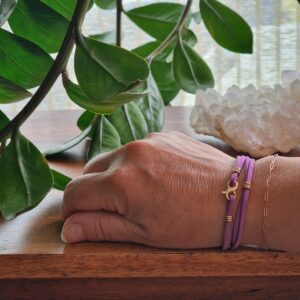 Bracelet double en faux daim mauve, avec mousqueton en laiton doré et 9 anneaux en plaqué flash or 18K, présenté sur fond clair. Modèle décliné en 15 couleurs élégantes.